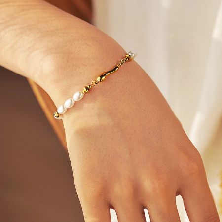 A model wearing the layered set of five vintage pearl and beaded bracelets.