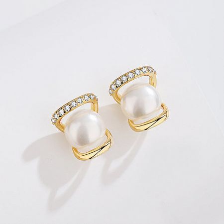 Close-up of the gold-plated pearl and CZ stud earring, highlighting the brilliant stone and lustrous pearl.