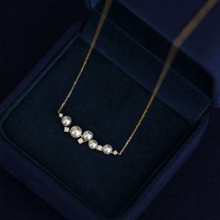 Elegant 18K gold plated shell pearl necklace on a neutral background.