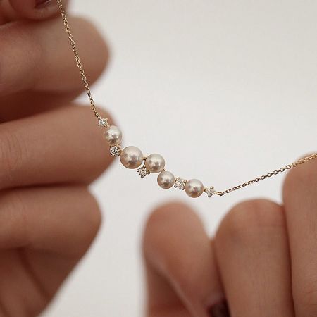 Detailed view of the shell pearl and 18K gold plating on the sterling silver necklace.