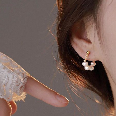 Close-up view of a single 14K gold plated earring showcasing three unique baroque freshwater pearls.