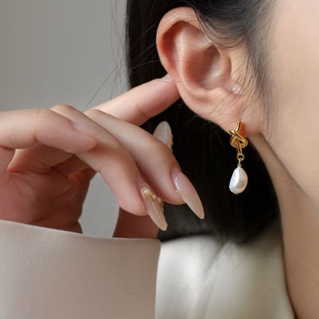 Close-up view of the vintage knot pearl drop earring in gold plate.