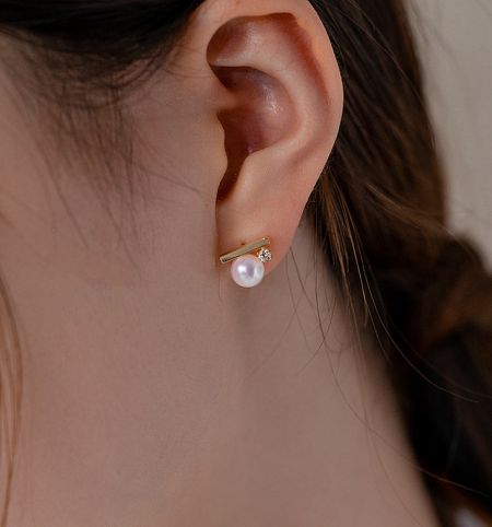 Close-up of the 925 sterling silver pearl stud earring being worn, highlighting its shine and detail.