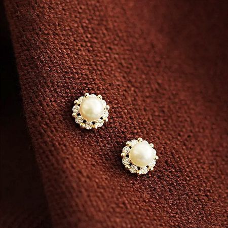 Another design from the set, featuring gold settings with clear stones and pearl centers.