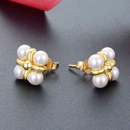 Angled shot of the four-pearl stud earrings, highlighting the gold finish.