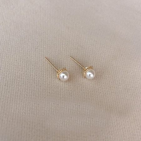 Another angle of the gold pearl stud earrings, highlighting the pearl's luster.