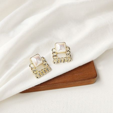 Another pair from the five-piece set, featuring a classic gold and pearl design.