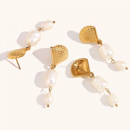 Another angle of the gold and pearl earrings, showing the textured metal components and the natural shape of the baroque pearls.