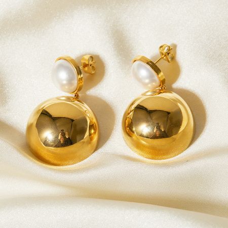 Another angle of the gold and pearl earrings, highlighting their glossy finish.