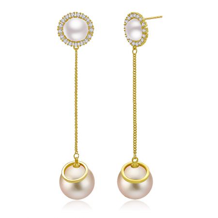 Angled shot of the dangling gold pearl earrings highlighting the clear stones.