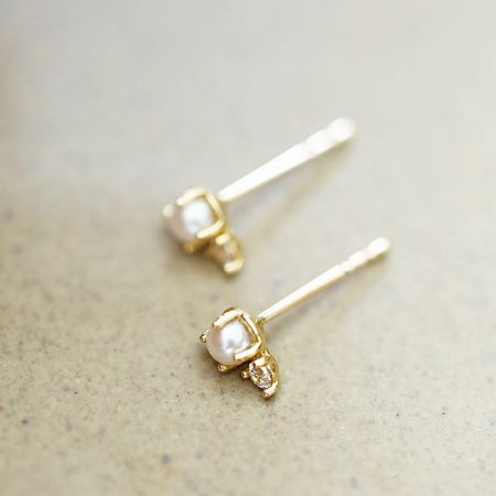 Macro shot highlighting the quality of the pearl and gemstone setting in the gold earring.