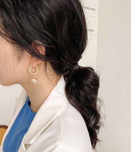 Model showcasing the elegant Pearl Vintage Gold Huggie Earrings to highlight their style when worn.