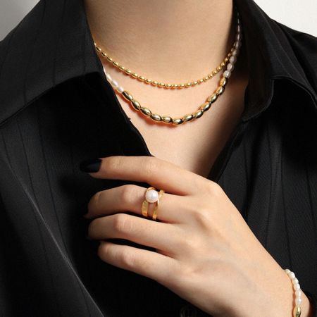 Detailed view of the 18K gold plated necklace with rice pearls.