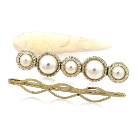A pearl barrette and a gold hairpin from the collection, highlighting their intricate design.