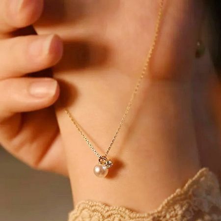 Another angle of the elegant gold necklace with pearl pendant.