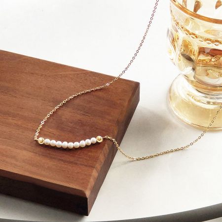 The freshwater pearl necklace set arranged on a wooden display, highlighting its aesthetic appeal.