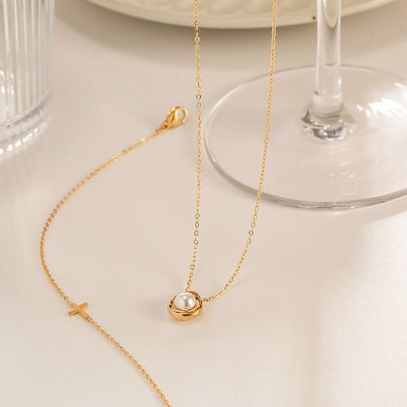 Full view of the gold pearl pendant necklace showing the delicate chain and clasp.