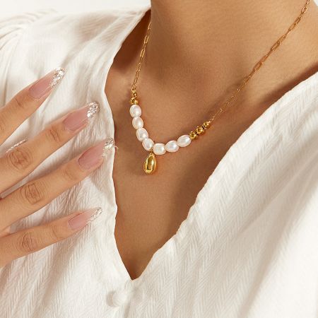 Front view of the baroque pearl pendant necklace against a neutral background.