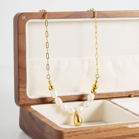 The pearl choker necklace elegantly displayed in a wooden jewelry box.