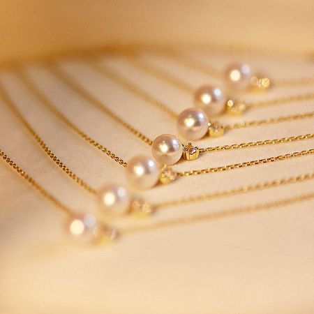 Multiple gold pearl necklaces displayed together.