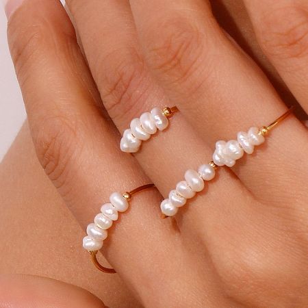 A model's hand displaying two gold rings from the baroque freshwater pearl set, demonstrating how they can be stacked or worn separately.