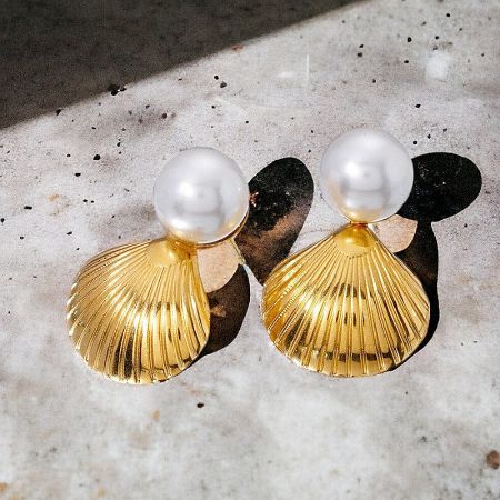 Pair of pearl and gold earrings with seashell design.