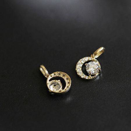 Detailed view of the gold-plated half-moon pendants with clear CZ stones.