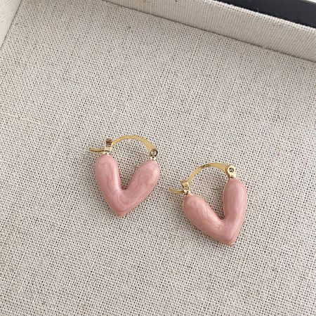 Detailed view of the double-sided pink enamel and 14k gold plating on the heart hoop earrings.
