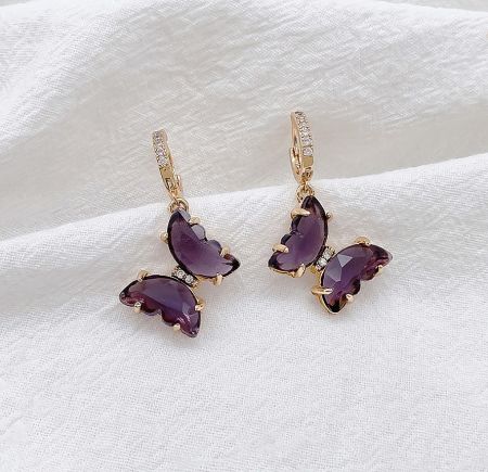 Side view of the gold purple butterfly huggie earrings, highlighting the delicate butterfly design and gemstone setting.