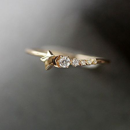 A close-up view of the gold star ring, highlighting the detailed craftsmanship and diamond design.