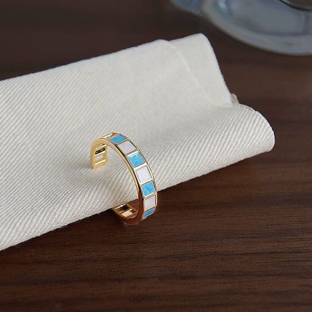 Side view of an open finger ring showcasing the fine craftsmanship of the blue and white enamel work.