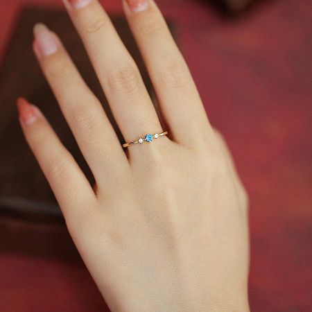 The September birthstone ring being worn on a finger to show scale and appearance.