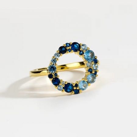 A stylish gold-plated sterling silver ring with a round blue CZ, perfect for stacking.
