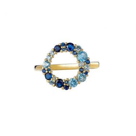 Close-up of a delicate gold-plated ring featuring a central blue CZ surrounded by smaller clear stones.