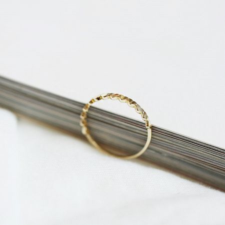 Detailed view of another ring in the set, featuring a beautiful braided design.