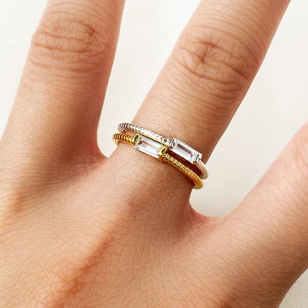 Detailed close-up of the gold twisted rope ring, highlighting the rectangular gemstone and intricate band design.