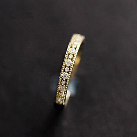 Detailed product shot of a single gold zircon ring from the set.