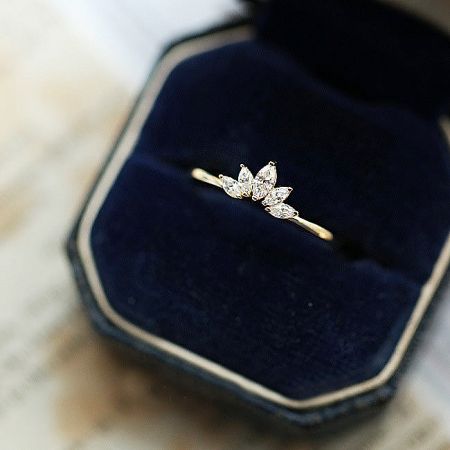 Gold lotus petal ring with five gemstones presented elegantly in a dark blue velvet box.