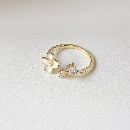 Gold ring with a delicate flower and sparkling zircon stone design.