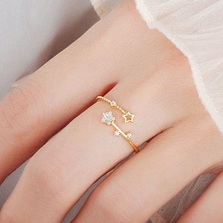A delicate gold ring showcasing an intricate flower and star motif.