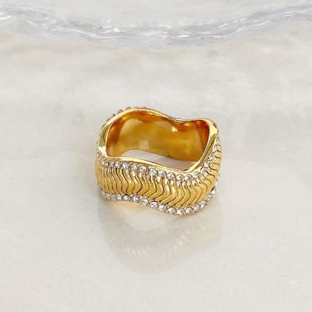 Close-up of a gold ring with clear gemstones from the wavy ring set.