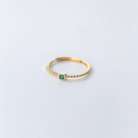 Detailed side view of the gold-plated sterling silver emerald ring.