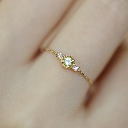 A woman's hand wearing the adjustable olivine zirconia birthstone ring, showcasing its elegant fit.