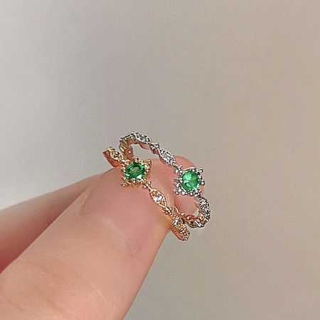 A stunning gold ring from the set, featuring multiple green and white stones.