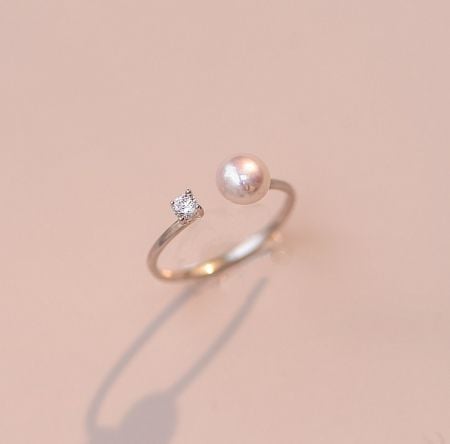 925 Sterling Silver Pearl Opening Ring - A close-up of the 925 Sterling Silver Pearl Opening Ring, showcasing its gold plating, central pearl, and accent cubic zirconia stone on a white background.