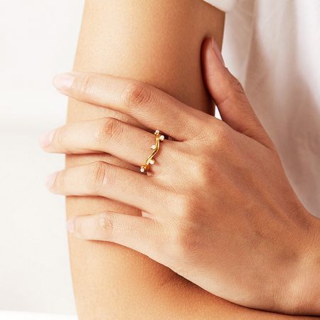 Close-up of the irregular wave branch pearl open ring on a model's hand.