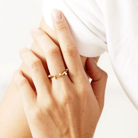 Detailed view of the gold-plated stainless steel ring with pearl accents.