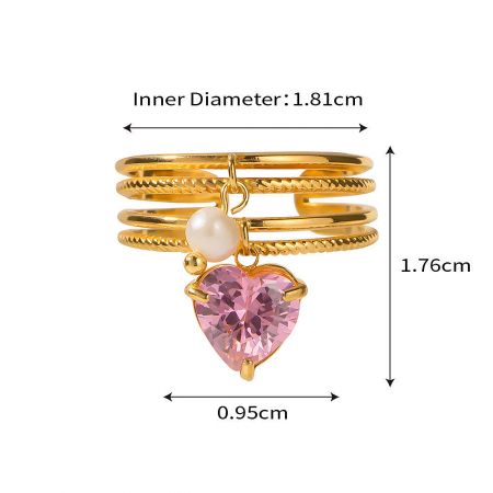 The heart-themed ring from the set, featuring a pink gemstone and a delicate pearl.