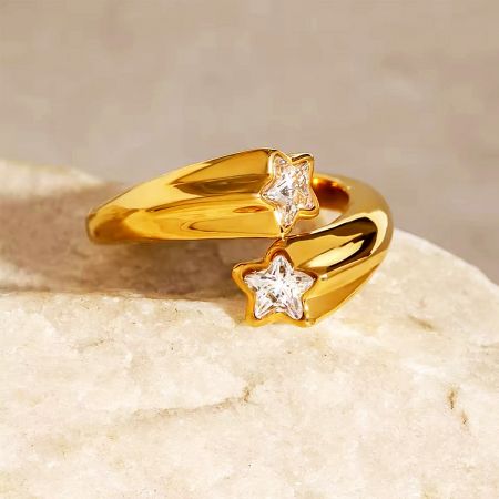 Close-up of a gold star ring with clear gemstones.