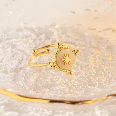 A square-stoned gold ring from the set, showcasing a radiant sunburst pattern.